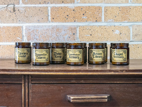 Valiant candles in amber jars on a wooden dresser